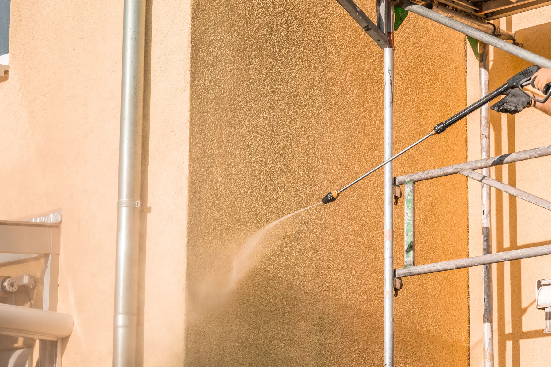 Männlicher Arbeiter wäscht Fensterglas von außen